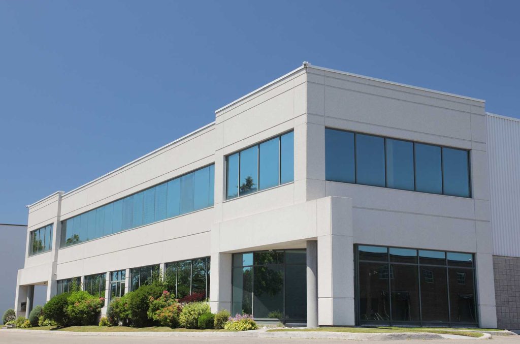 PMB Facade - Low-rise commercial facade with aluminum curtain wall system and glass panel cladding.