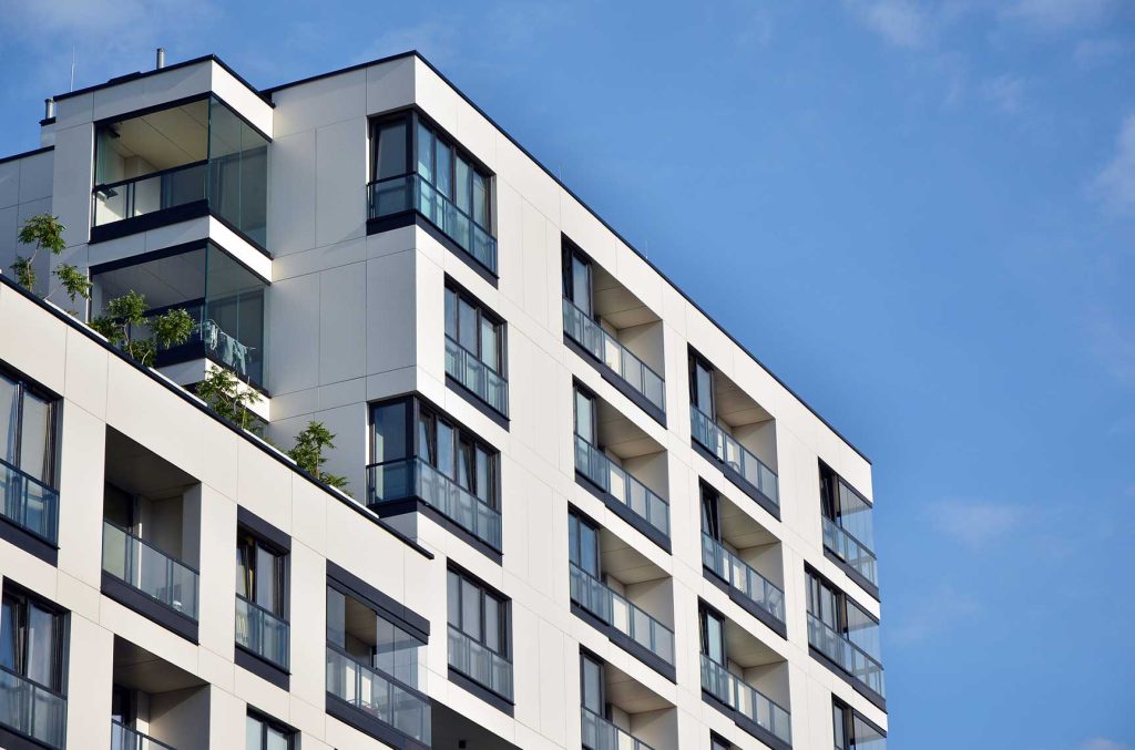 Modern tower with glass curtain wall system, showcasing vertical fins and unitised curtain wall design.
